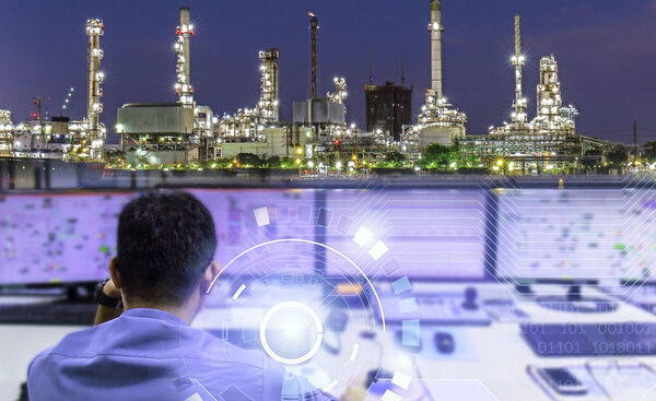 operator in control room at night with plan views